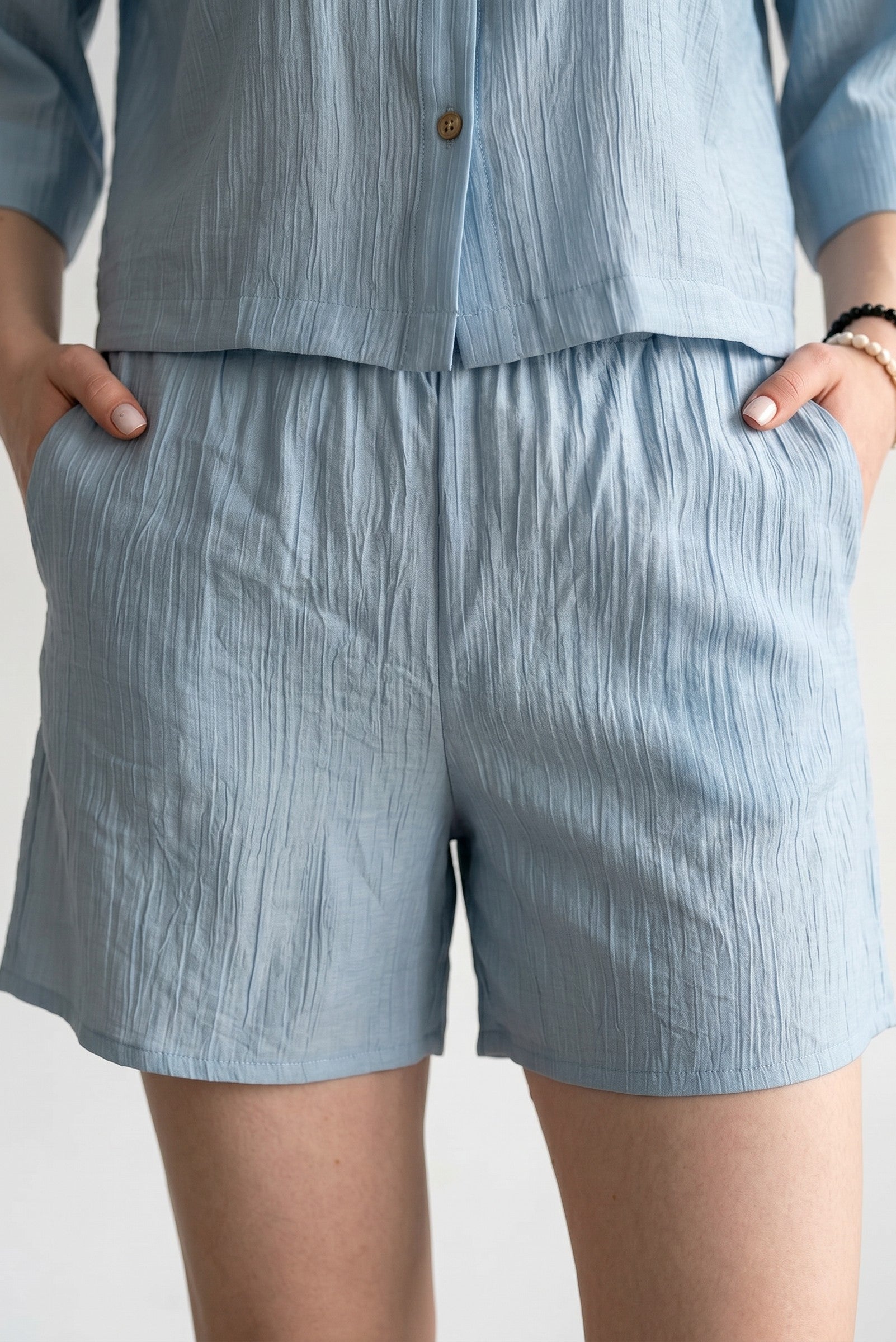 Pantaloni scurti damă cu talie elastică și textură gofrată, purtați într-o ținută casual de vară.